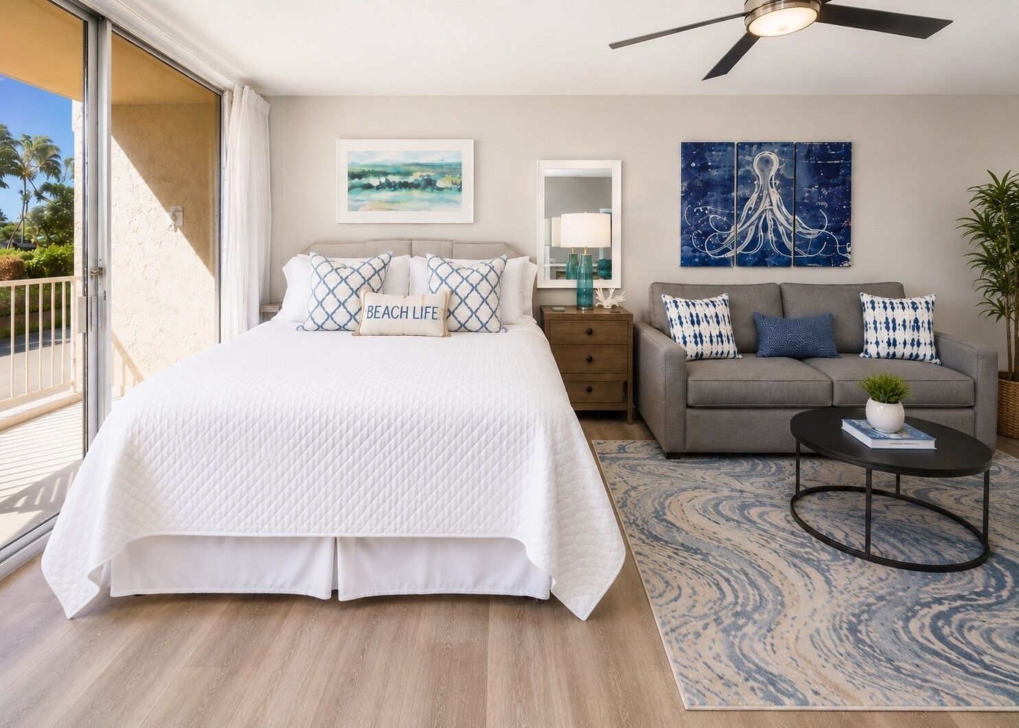 Une chambre à coucher avec un lit, un canapé, une table basse et des œuvres d’art accrochées aux murs.
