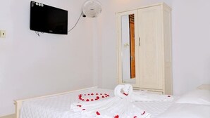 A hotel room with a bed, a television mounted on the wall, and a wardrobe. - Thanh Cuong Hotel (Nha Trang)
