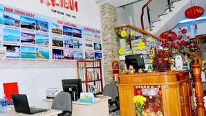 A hotel reception area with a desk, computer, and a bookshelf. - Thanh Cuong Hotel (Nha Trang)