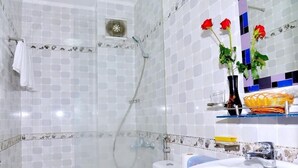 A bathroom with a glass-enclosed shower, a white sink, and a mirror with a decorative border. - Thanh Cuong Hotel (Nha Trang)