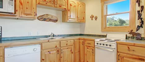 A kitchen with wooden cabinets, a microwave, a stove, and a dishwasher.