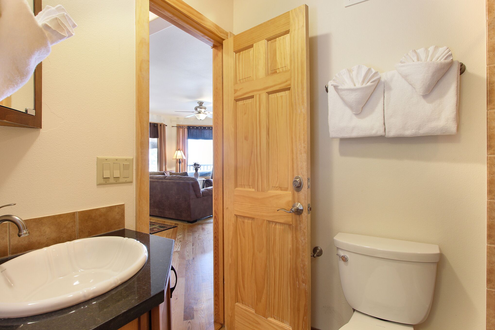 Un bagno con un lavandino bianco, una porta in legno e un water.