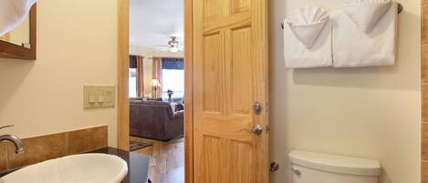 Un bagno con un lavandino bianco, una porta in legno e un water.