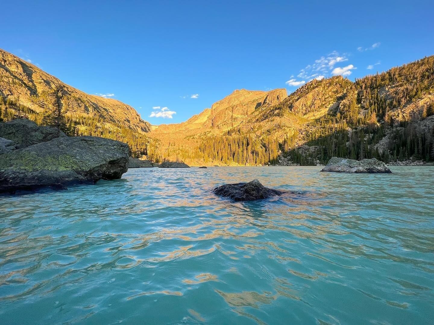 A river flowing through a mountainous landscape with rocky outcrops and dense forests.