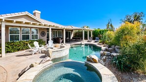 Un espace piscine comprenant un jacuzzi, des chaises longues et un patio couvert.