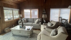 A cozy living room with a sofa, armchairs, and a coffee table. There are windows with blinds, a lamp, and a wooden ceiling. - Secluded Waterfront Get Away on Smith Mountain Lake  (Huddleston)