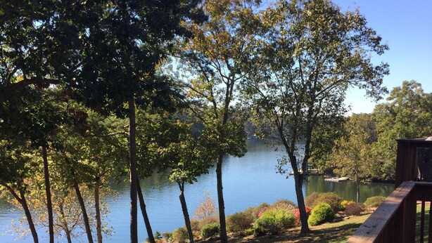 A wooden deck overlooking a lake with trees and a small shed. - Secluded Waterfront Get Away on Smith Mountain Lake  (Huddleston)