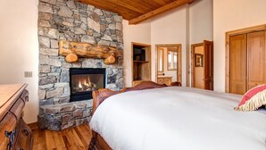 A bedroom with a stone fireplace, wooden ceiling, and a large bed. - Excellent Location! Walk to Snow Park Lodge (Deer Valley)