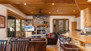 A spacious living area with a stone fireplace, leather furniture, and a wooden ceiling. - Excellent Location! Walk to Snow Park Lodge (Deer Valley)