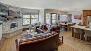 A spacious living area with a fireplace, comfortable seating, a dining area, and a kitchen. - 4br Renovated - Sleeps 12- Downtown Breck by RedAwning (Breckenridge)