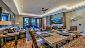 A spacious living area with a large dining table, comfortable seating, and a fireplace.