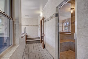 A modern bathroom with a glass shower enclosure, a wooden bench, and a view of the outside through a window. - Spacious  In The Heart Of Breckenridge Studio Condo by RedAwning (Breckenridge)