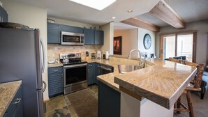 A modern kitchen with a central island, built-in appliances, and a skylight. - Lovely Modern Plaza Condo - No Cleaning Fee! by RedAwning (Crested Butte)