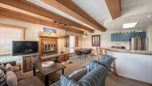 A modern living room with a fireplace, a television, and a dining area. - Lovely Modern Plaza Condo - No Cleaning Fee! by RedAwning (Crested Butte)