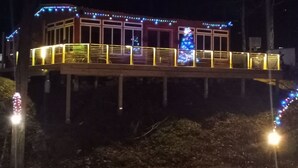 Een gebouw met een overdekt terras, een hekwerk en een kerstboom.