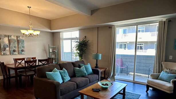 A living room with a sofa, coffee table, and dining area. - Updated Condo Near Beaches, Downtown, Restaurants, and Shops (Grand Haven)