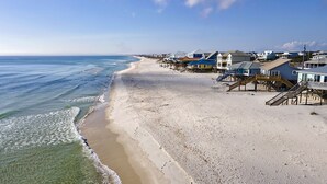Ein Strand mit Häusern und Holzbodenwegen entlang der Küste.