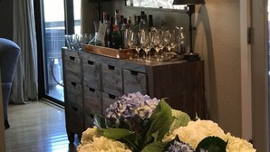 A bar area with a wine rack, glasses, and bottles. There is a window with curtains and a view of trees. - Sonoma Valley-Beautiful Glen Ellen Wine Country Retreat - Amenities Galore! (Glen Ellen)
