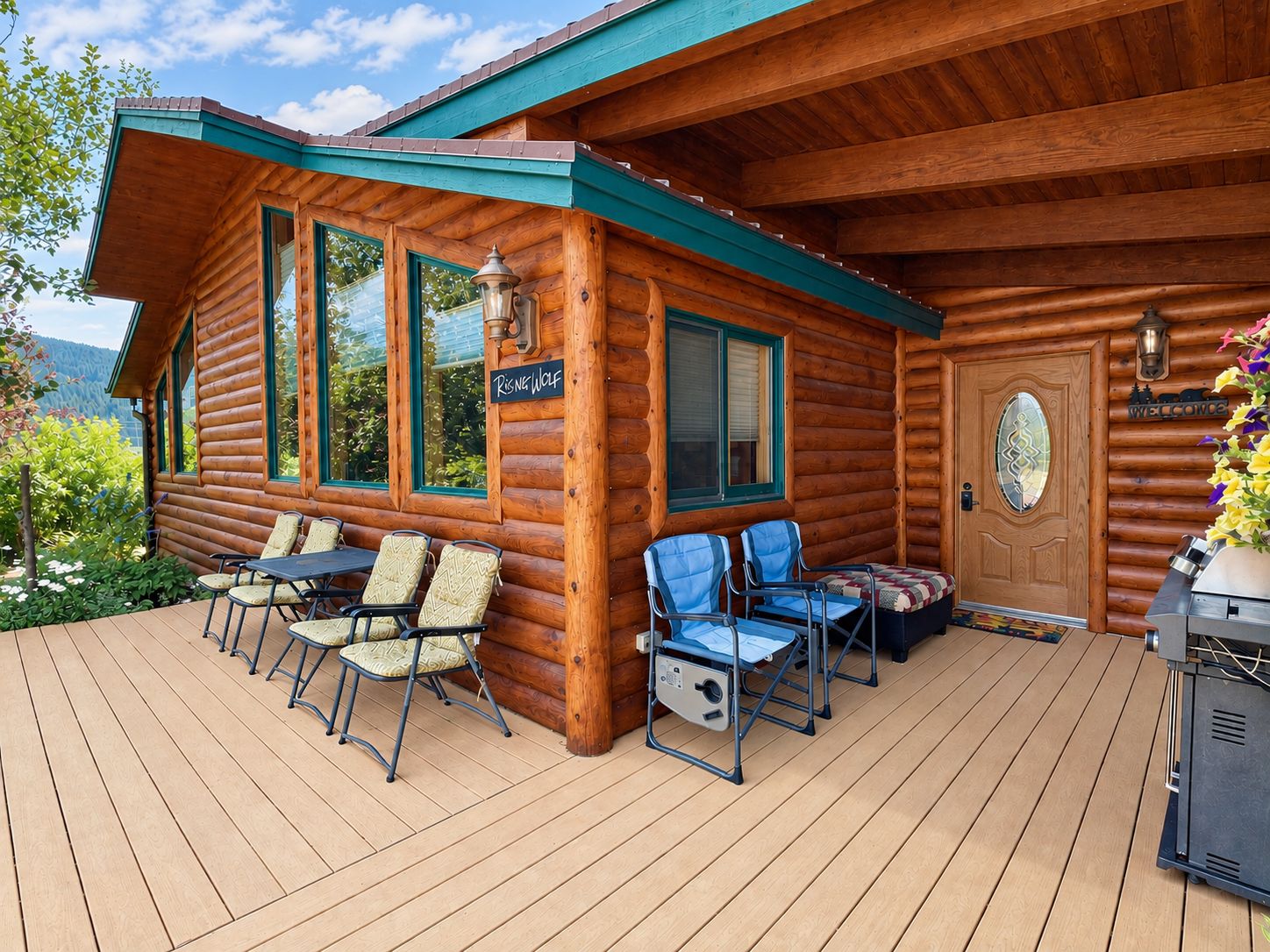 Une cabane en rondins avec une terrasse, des sièges d’extérieur et un panneau d’accueil.
