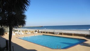 A pool area with lounge chairs and a view of the beach and ocean. - Luxurious Oceanfront Condo Ocean Views throughout in prestigious Maisons-sur-Mer (Myrtle Beach)
