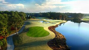 A golf course with a water body, a walking path, and a wooded area. - 1380 Laurel Grove 3 Bedroom Home by RedAwning (Miramar Beach)