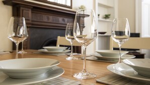 A dining table set with white plates, bowls, and wine glasses. - Henderson - New Town Apartment (Edinburgh)