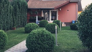 Una casa con fachada roja, techo inclinado y un pequeño porche delantero.