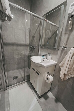 Habitación individual | Baño | Ducha, artículos de higiene personal gratuitos y secador de pelo