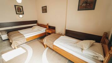 A bedroom with two single beds, a bedside table, and a nightstand.