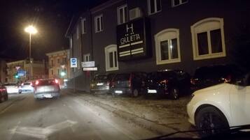 A hotel with a sign reading "H GULLETTA" on the facade, parked cars along the street, and a traffic light visible.