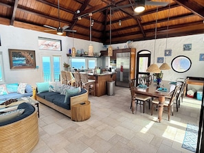Un salón amplio con sofá, mesa de comedor y zona de cocina.