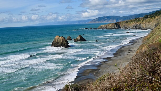 A coastal landscape with rocky outcrops and a sandy beach. - Beautiful Home in the Heart of the Majestic Redwoods.  Secluded on 10 acres. (Fort Bragg)