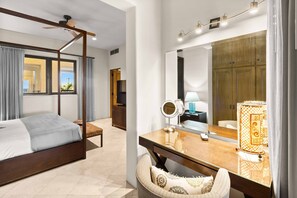 Relax in a serene space with a four-poster bed, vanity, and comfortable seating area.