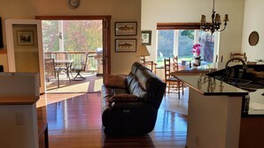 A living room with a sofa, a television, and a kitchen area with a sink and counter.