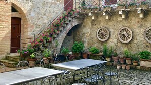 Une cour avec un sol en pierre, des sièges extérieurs et des plantes en pot.
