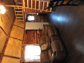 A wooden interior with a sofa, a door, and a staircase. - Lovely secluded rustic cabin within waking distance of Rocky Top Winery . (Atwood)