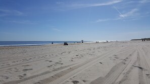 A wide sandy beach with footprints and a few people. - Heart of Beach Haven - LBI Oceanfront Condo; Inground Pool    (Beach Haven)