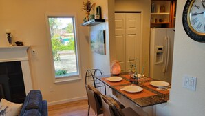 A modern kitchen with a dining area, a sofa, and a view of the outdoors. - Great Price! Sunset Beach Cottage with Lovely garden, beach, and boat dock! (Nice)