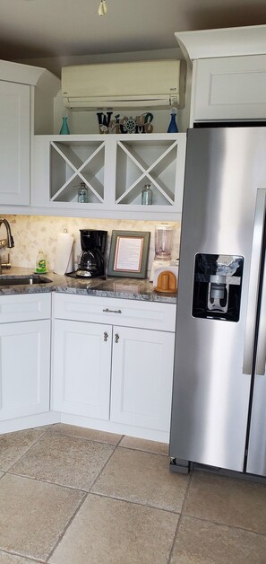 A kitchen with white cabinets, a stainless steel refrigerator, a coffee maker, and a framed picture on the counter. - 1-1/2 Blocks from the beach w/traffic light, Just remodeled   (Ship Bottom)