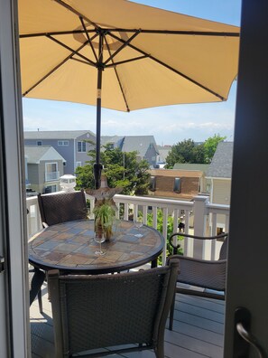 A balcony with a round table, two chairs, a potted plant, and a large umbrella. - 1-1/2 Blocks from the beach w/traffic light, Just remodeled   (Ship Bottom)