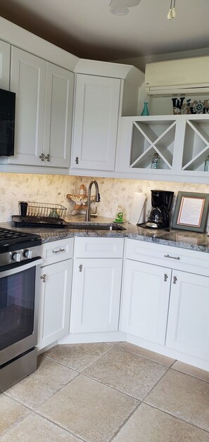A kitchen with white cabinets, a stove, a sink, and a coffee maker. - 1-1/2 Blocks from the beach w/traffic light, Just remodeled   (Ship Bottom)