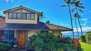 A two-story house with a tiled roof, a wooden front door, and a number '136' on the wall. - OCEANFRONT PUAMANA 136-1 - FUN IN THE SUN! (Lahaina)
