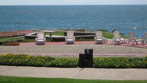 A seaside patio with white lounge chairs and a table, overlooking the ocean. - DELUXE VILLA FOR 6 GUESTS-2 BEDROOM,1BATH (Rosarito)