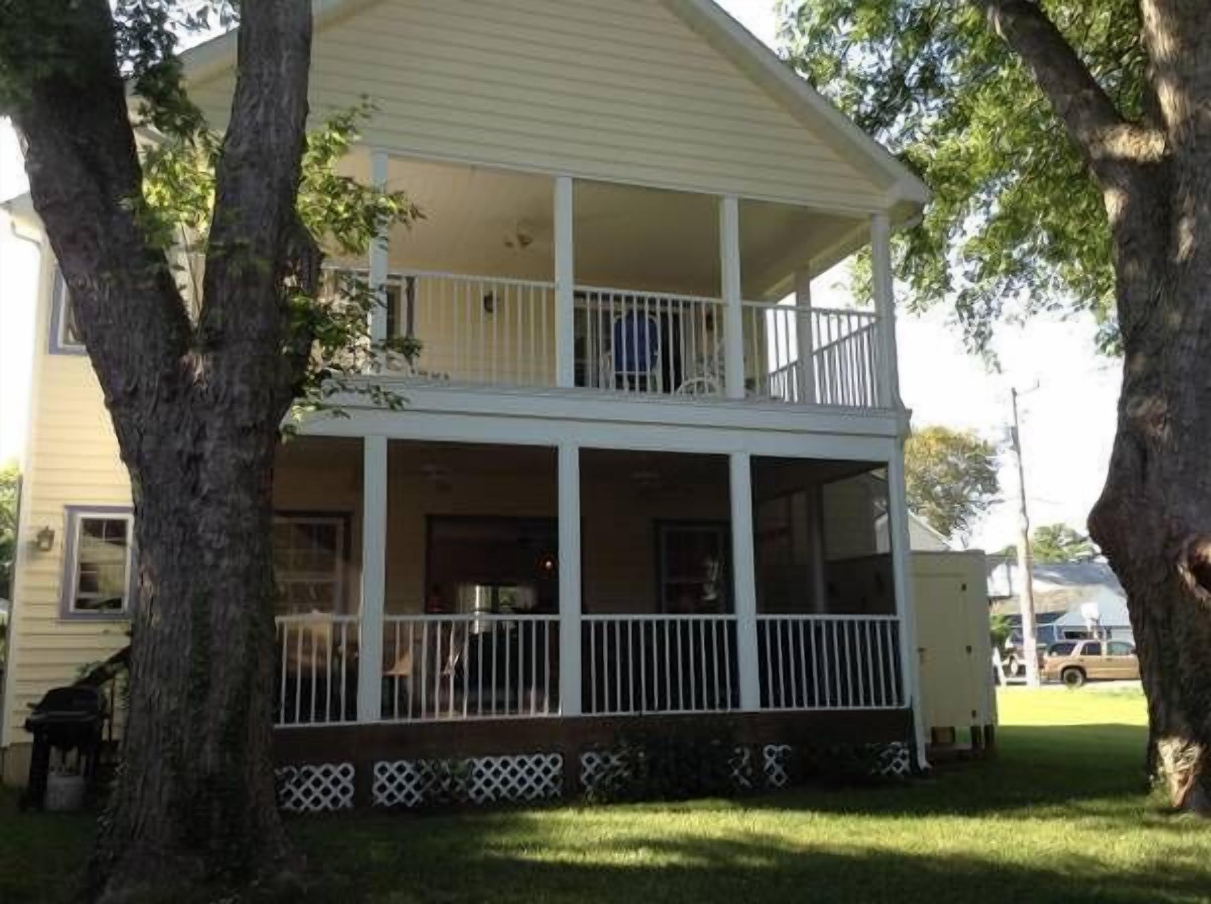 Rear view of house showing screened porch and full covered deck upstairs