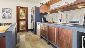 Eine moderne Küche mit Holzausstattung, inklusive Backofen, Kühlschrank und Spüle.