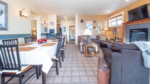 A dining area with a table set for four, a sofa, and a fireplace.