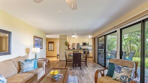 A spacious living area with a sofa, coffee table, and a dining table with chairs. There is a kitchen in the background with a refrigerator and microwave. - WAILEA JEWEL; NEAR BEACHES; SHOPS/5 STAR HOTELS; CONVENIENT! (Kihei)