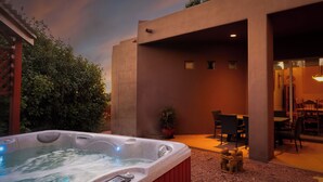 A hot tub in a covered outdoor area with a patio and seating. - Spectacular Red Rock Views from Gorgeous Pueblo-style Sedona Home with hot tub! (Sedona)