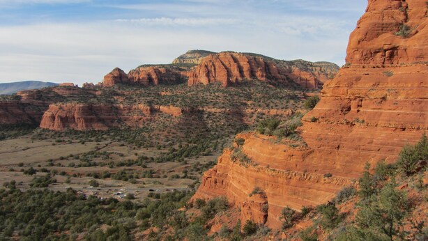 A rugged landscape with red rock formations and sparse vegetation. - Spectacular Red Rock Views from Gorgeous Pueblo-style Sedona Home with hot tub! (Sedona)