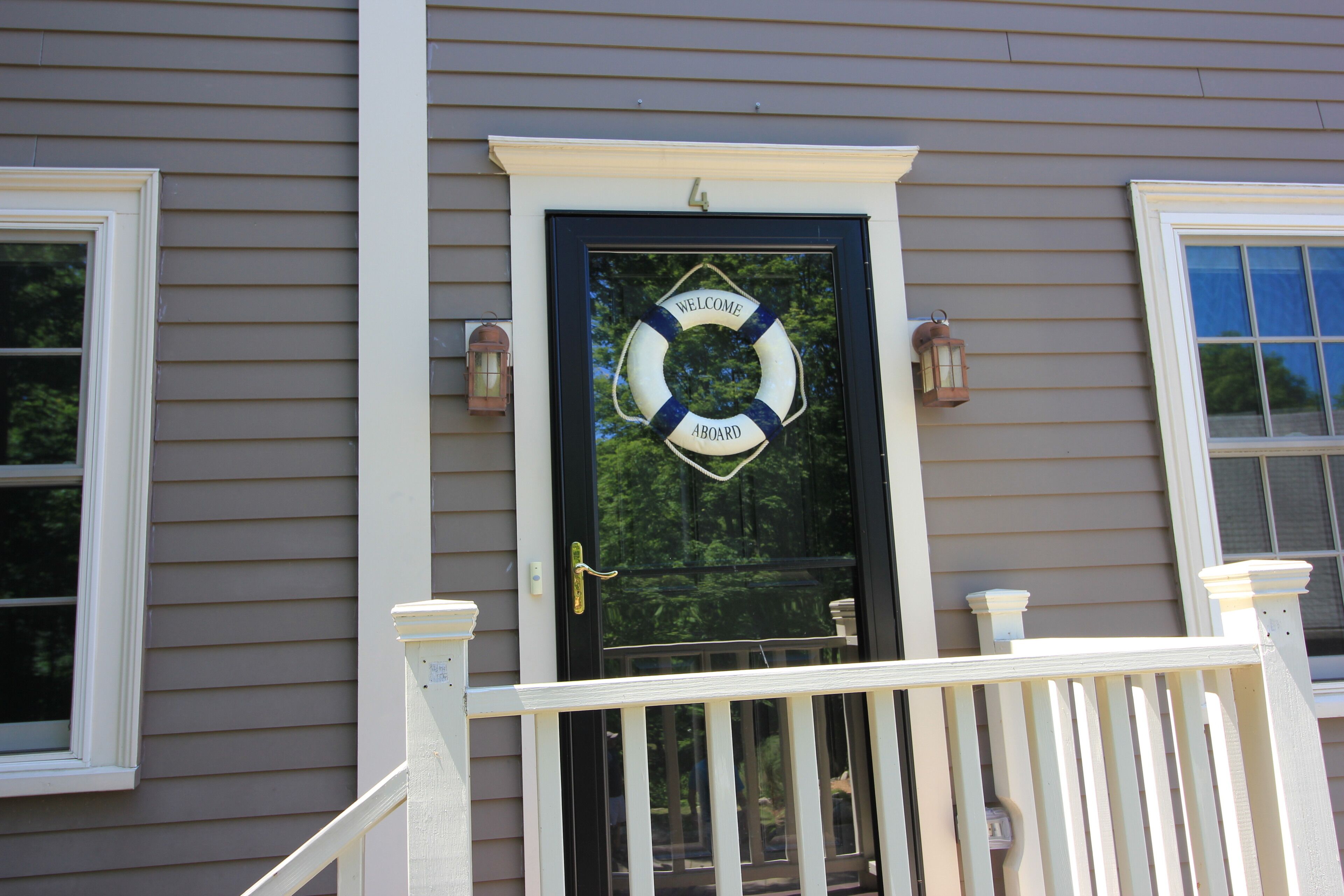 A house with a black door, a welcome sign, and a number '4' above the door.